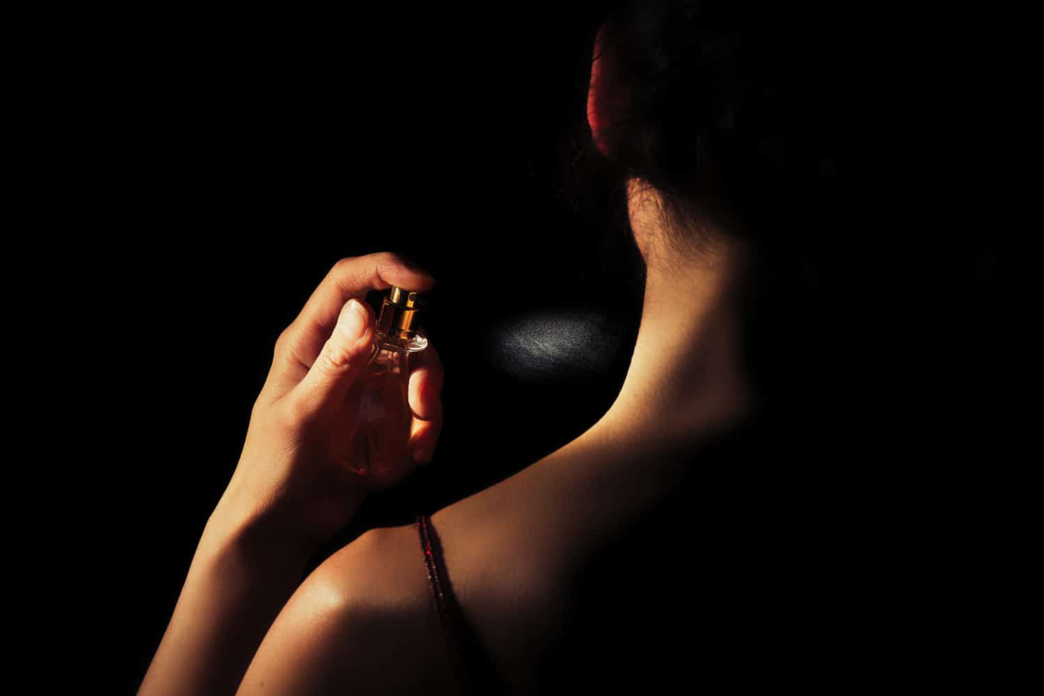 kobieta psikająca się uwodzicielskimi perfumami