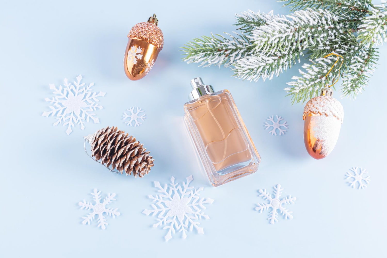 Damskie perfumy na jesień i zimę na niebieskim tle z śnieżynkami