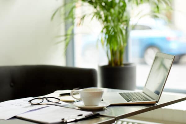 Biurko z laptopem, kawą i okularami