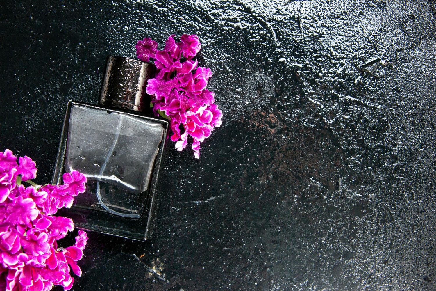 Perfumy o zapachu bzu na czarnym tle